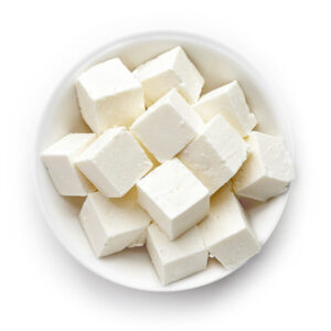 A white bowl of cubes of feta cheese
