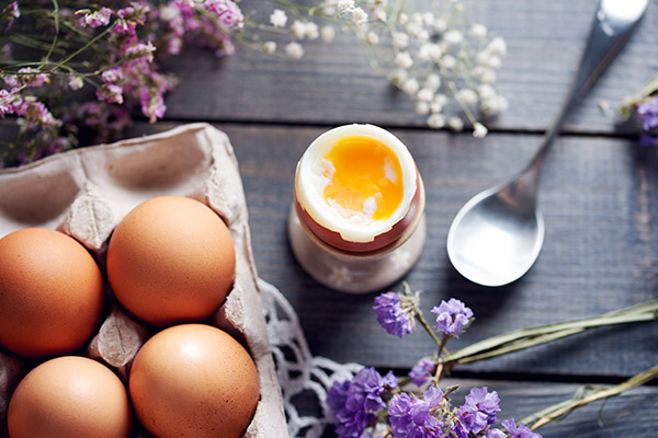 Boiled egg with the top removed in an egg cup