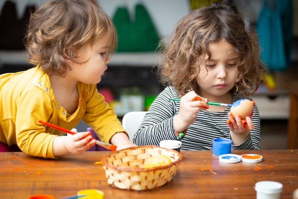 Two children decorating eggs for easter